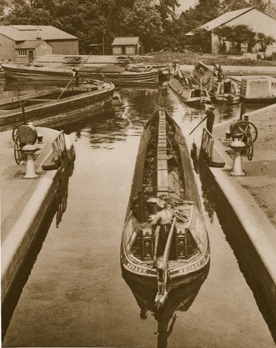 Ein Affenboot durch eine Schleuse in Brentford schieben von English Photographer